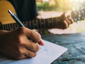 Man playing guitar with superimposed sound waves moving outward from him